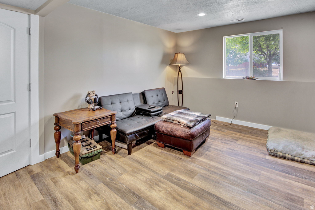 Finished room featuring wood-finish flooring, recessed lighting, and a white-framed window