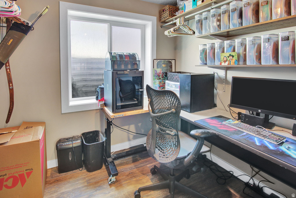 Dedicated office space with a window, wood-finish flooring, and neutral wall tones
