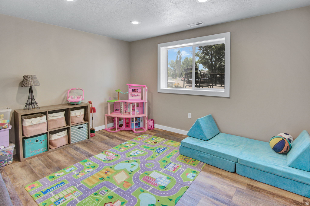 Bright room featuring wood-finish flooring, recessed lighting, and a large window with white trim