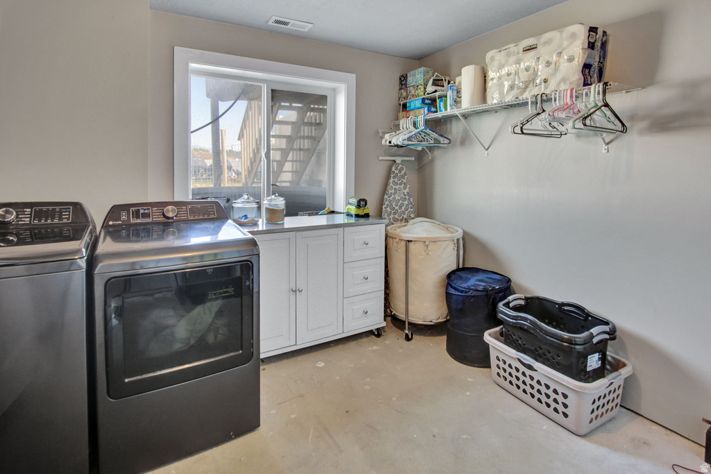 Dedicated laundry area featuring a built-in window, white cabinetry with a light-toned countertop, and open wire shelving