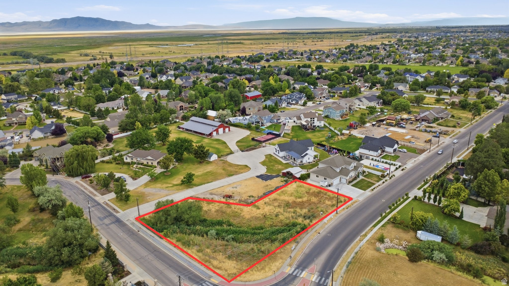 Expansive corner lot featuring a combination of natural vegetation and cleared areas, bordered by paved roads
