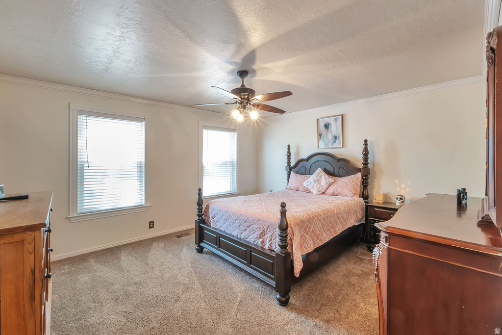 Neutral wall finishes with crown molding, two windows with blinds, and a ceiling fan with integrated lighting