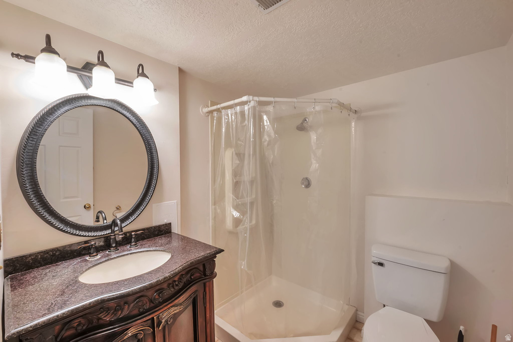 Bathroom vanity featuring an oval sink set into a dark countertop, complemented by a decorative framed round mirror