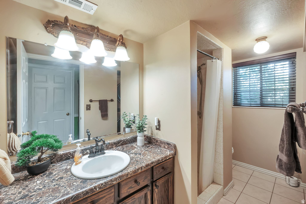 Bathroom featuring a vanity with a dark wood-finish cabinet, a single basin sink, and a stone-look countertop