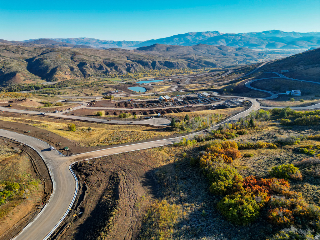 Expansive landscape featuring newly paved roads, two visible lakes, and distant mountains