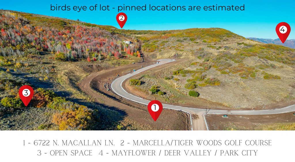 Expansive hillside lot featuring a paved road, natural terrain, and distant mountain ranges
