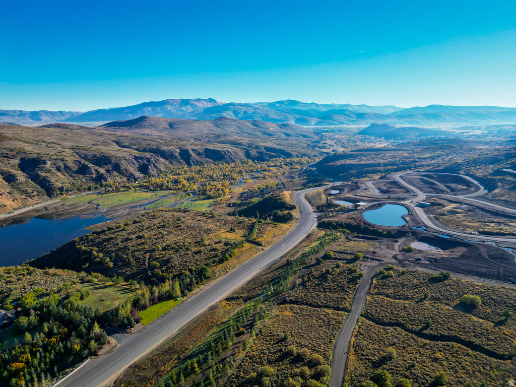 Expansive mountain landscape featuring paved roads and a tranquil lake