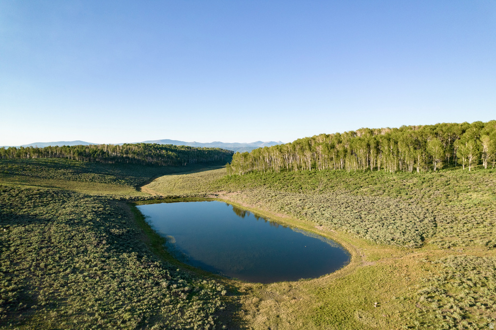 Natural water feature surrounded by sloped terrain and varied vegetation
