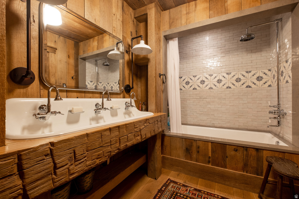 Bathroom featuring a triple basin sink with individual faucets, set into a substantial wood vanity