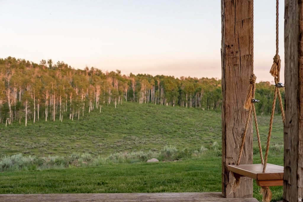 Rustic porch swing with rope suspension, supported by substantial wood posts