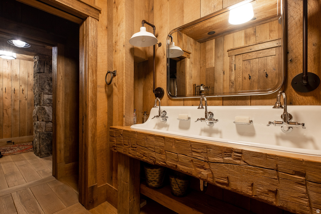 Double trough sink with wall-mounted faucets and exposed wooden beam vanity
