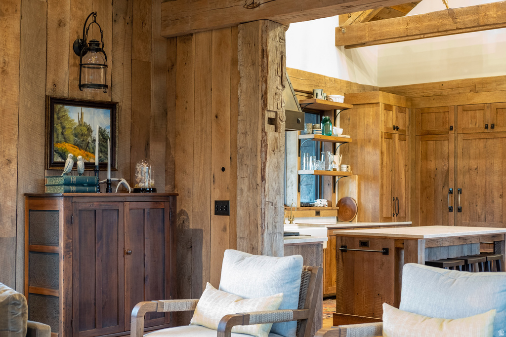 Rustic wood-paneled walls and exposed timber beams define this living area