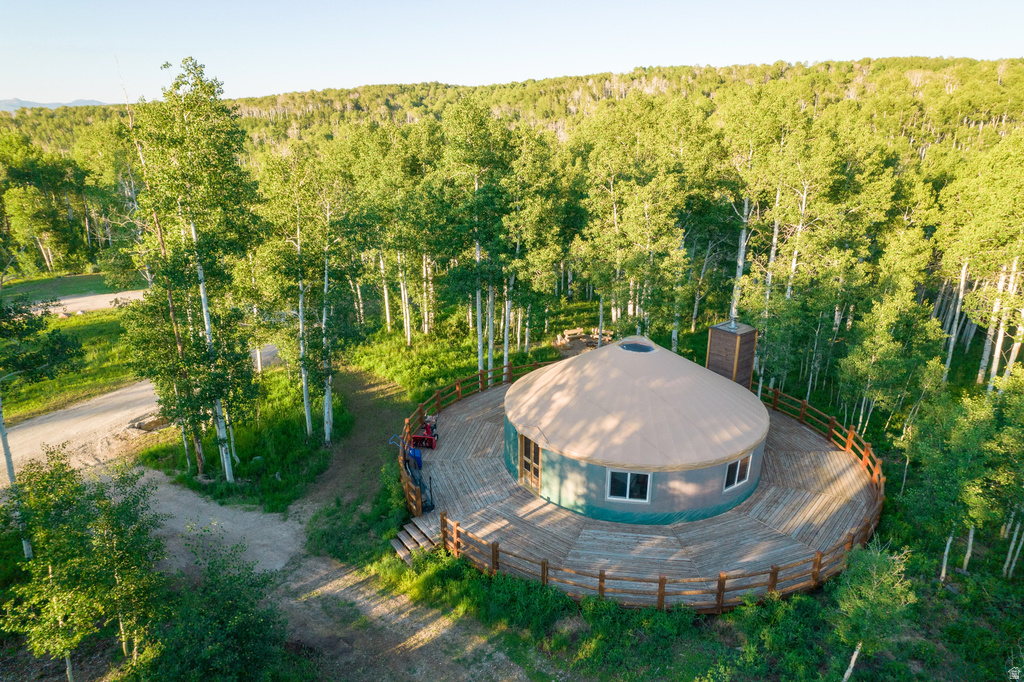Circular yurt structure featuring a light-colored domed roof and a dark-colored chimney