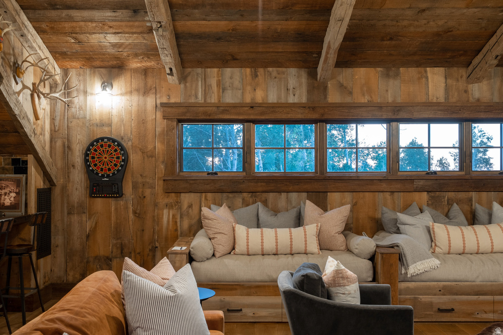 Reclaimed wood paneling and exposed beams accent this room featuring multiple transom windows, built-in seating, and a wall-mounted light fixture
