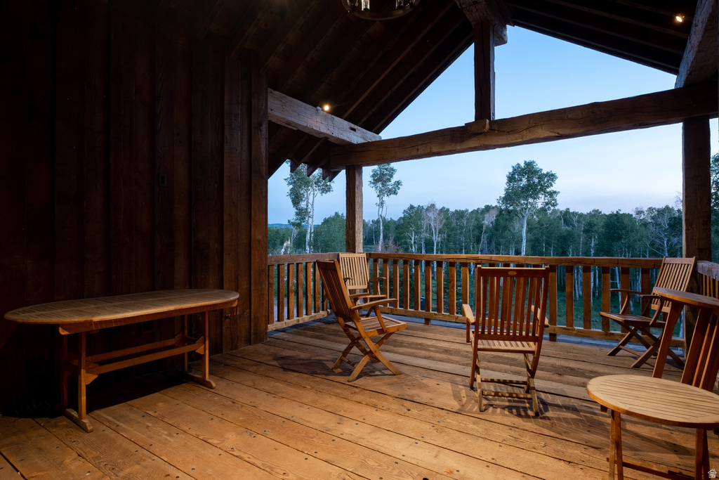 Spacious covered porch featuring exposed timber beams and a wood-plank floor