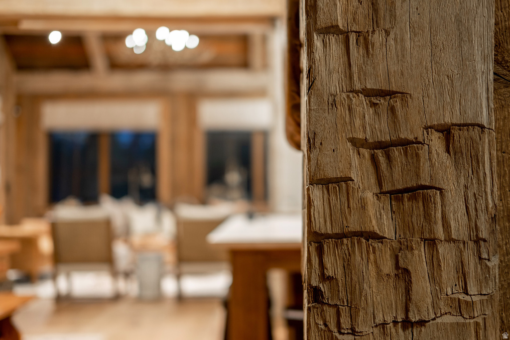 Textured wood column with visible grain detailing, complemented by a coffered ceiling and built-in lighting in the background