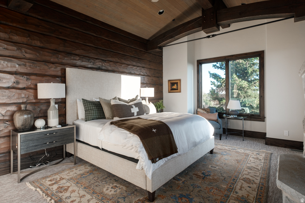 Bedroom featuring a wood-plank accent wall, wood-beamed ceiling, and large window with dark wood trim