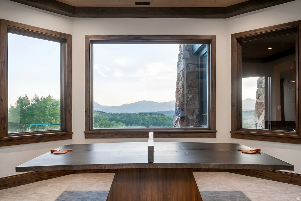 Expansive mountain scenery framed by multiple windows with natural wood trim