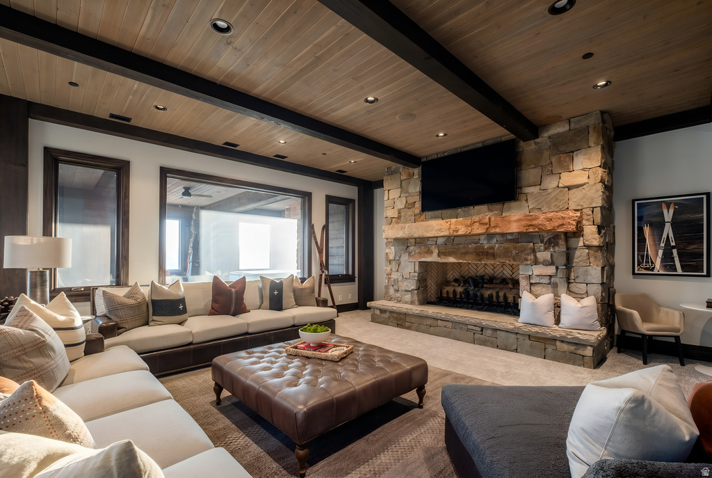Spacious living area featuring a prominent stone fireplace with a substantial timber mantel