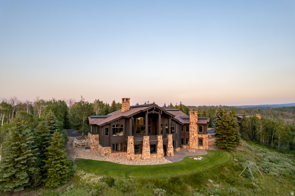 Expansive mountain-style residence featuring a prominent stone and wood exterior