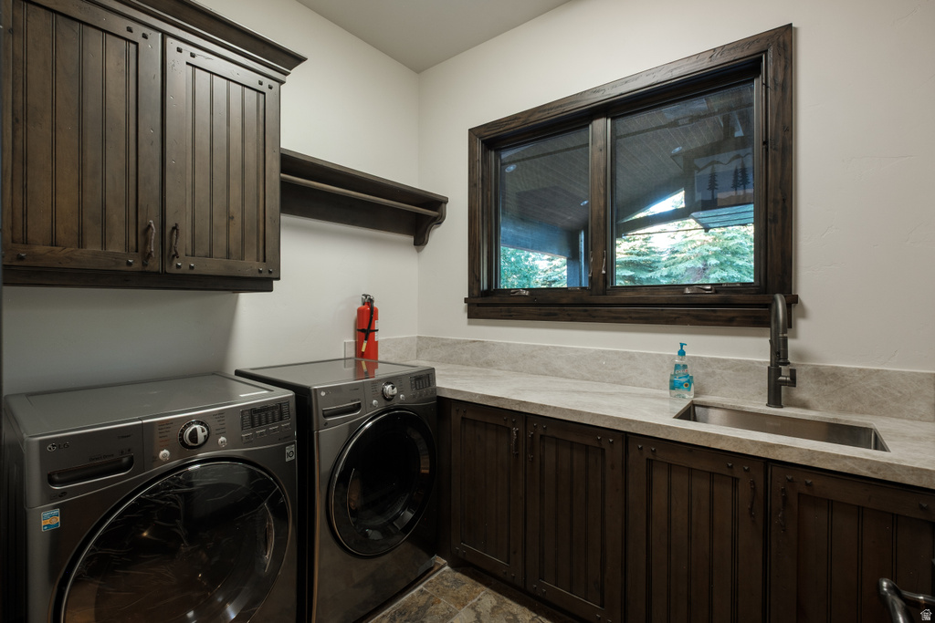 Laundry area featuring dark wood-finish cabinetry, a single basin sink with a matte black faucet, and light-toned countertops