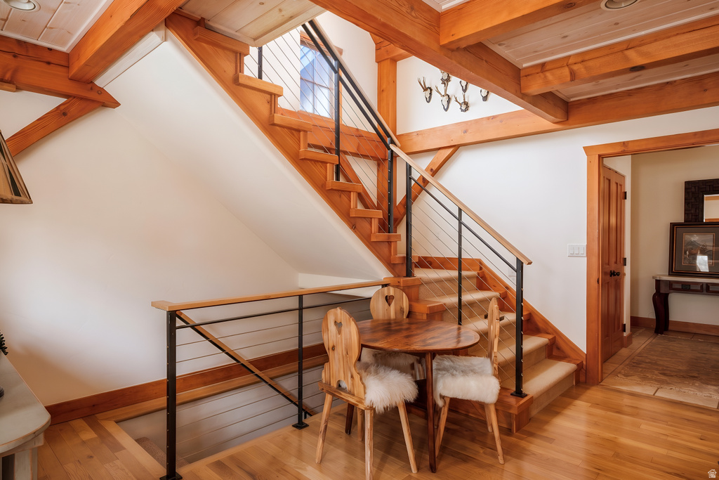 Staircase featuring wood construction, cable railing, and a landing with a wood-finish floor