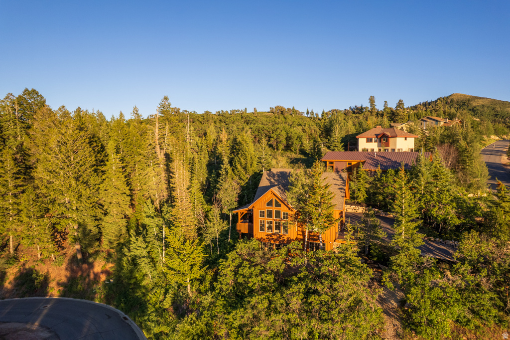 Wood-sided mountain home with a gable roof and large picture windows