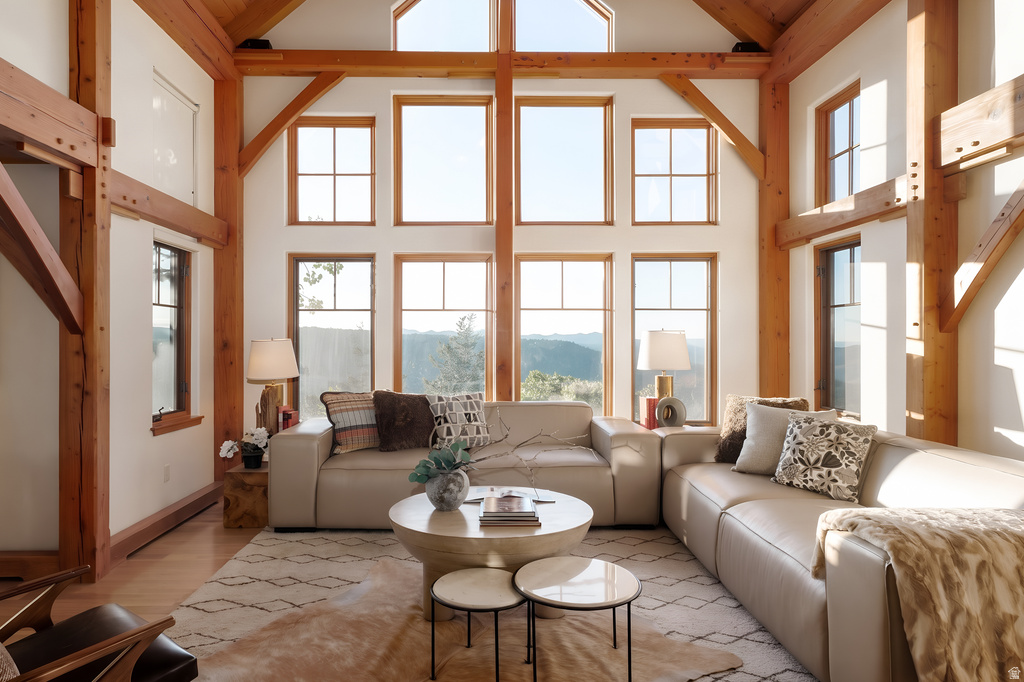 Spacious living area featuring exposed structural wood beams and a soaring vaulted ceiling