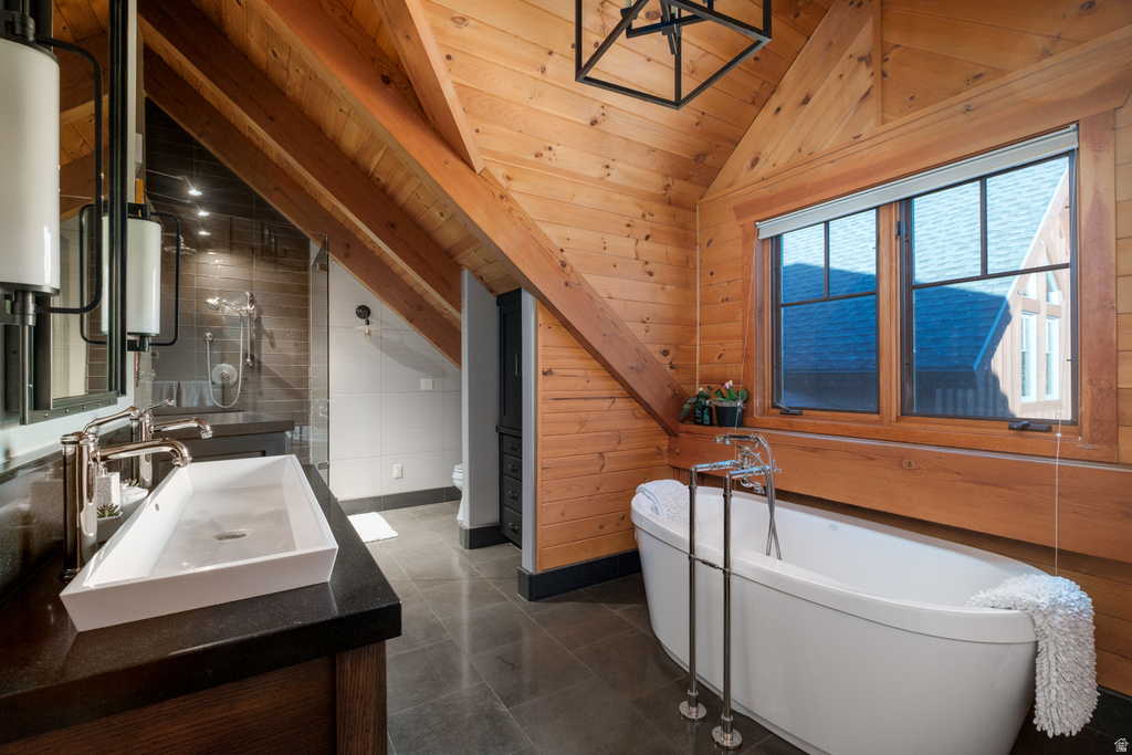 Attic bathroom featuring wood-paneled walls and ceiling with exposed beams