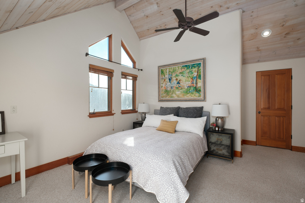 Bedroom featuring a vaulted wood-paneled ceiling, a ceiling fan, light-colored walls, and a paneled wood door