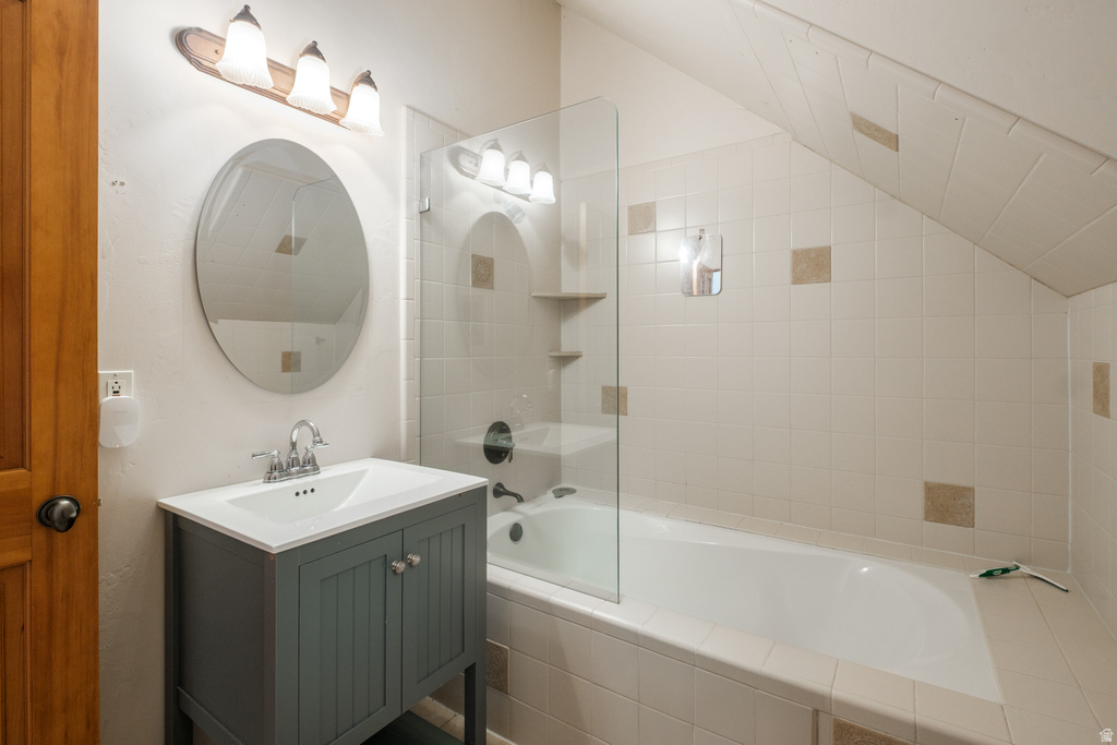 Bathroom featuring a standing vanity with an integrated sink, an oval mirror, and a three-light fixture