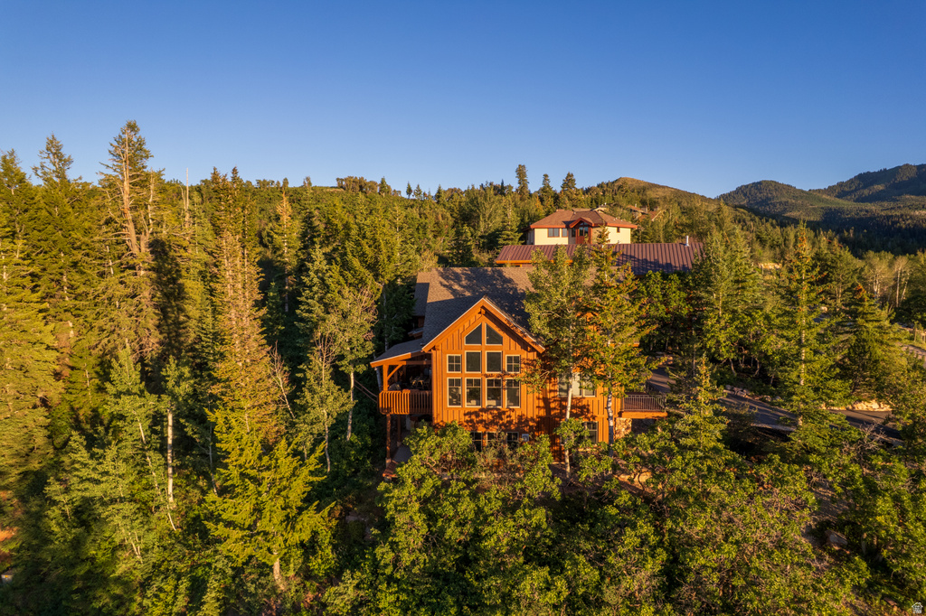 Wood-sided mountain home with a substantial gable roof and multiple large windows
