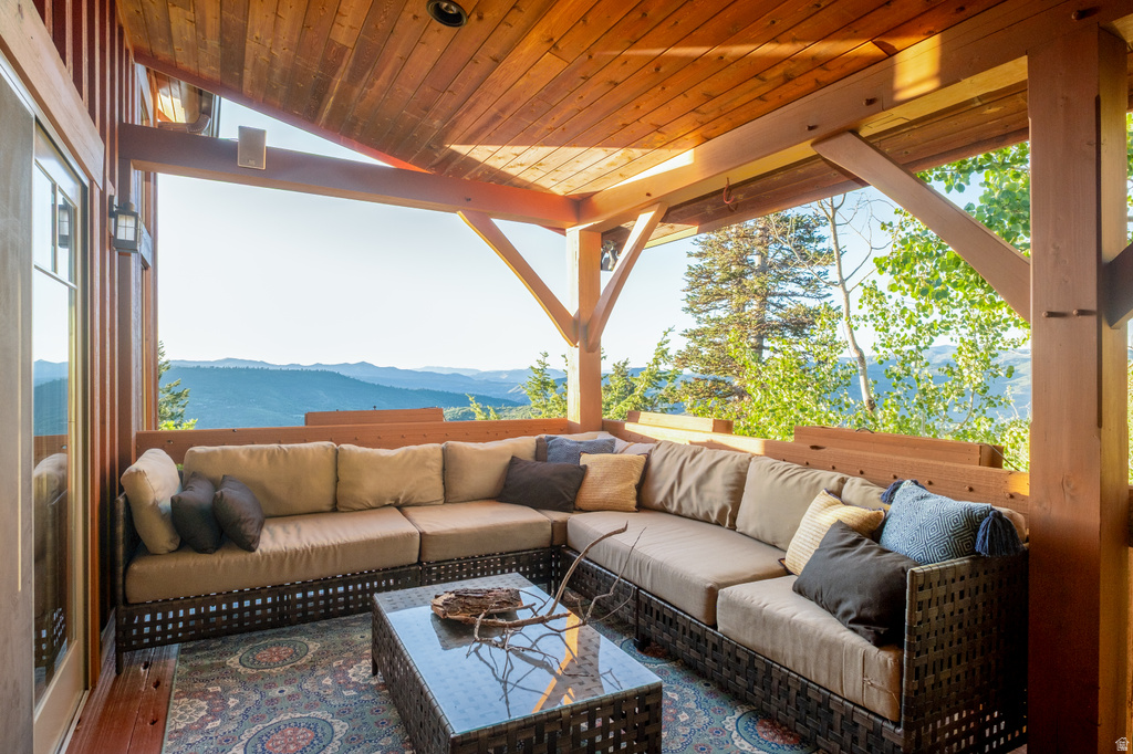 Expansive outdoor living area featuring a wood-finish ceiling, exposed structural beams, and recessed lighting