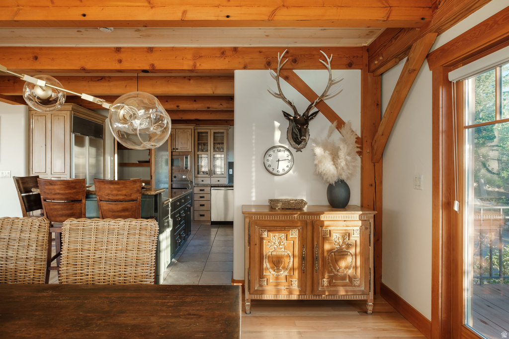Exposed timber beam ceiling, wood-finish flooring, and a window with wood trim
