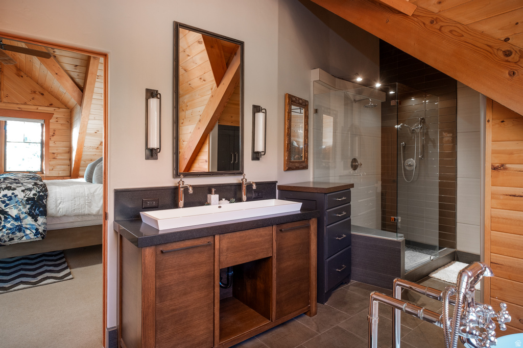 Dual-sink vanity with dark stone countertop, vessel sink, and modern wall sconces