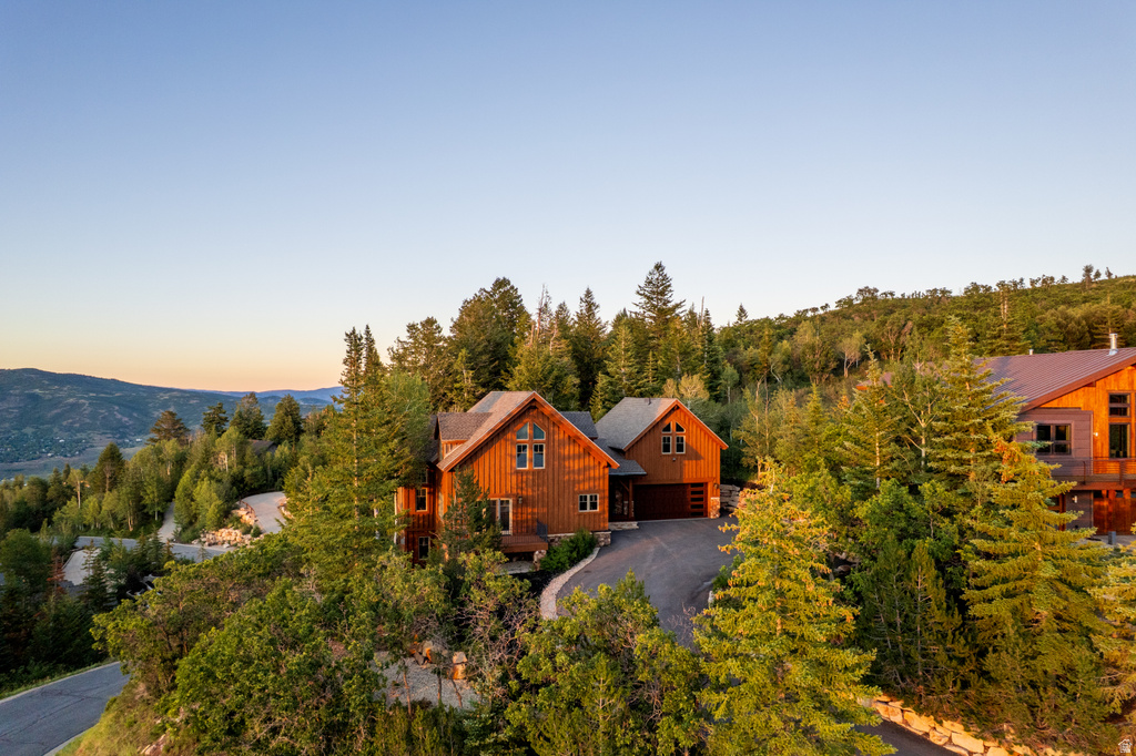 Wood-sided residence situated on a sloped, tree-covered lot