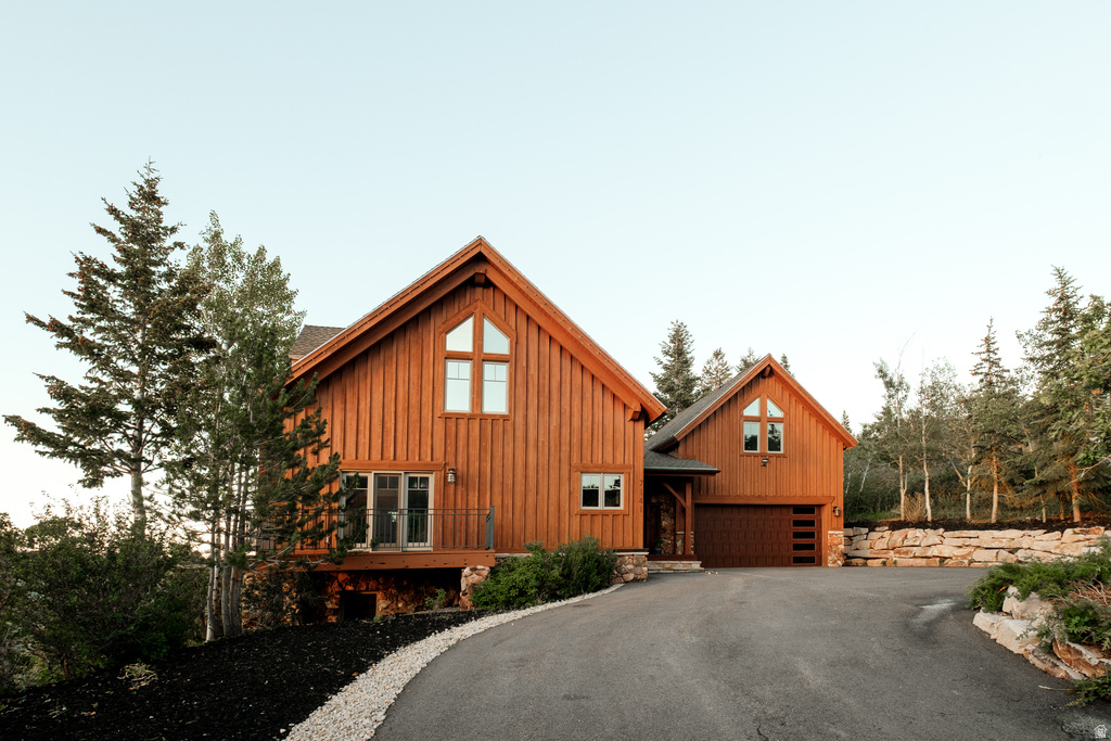 Wood-sided residence featuring a gabled roofline and multiple window styles