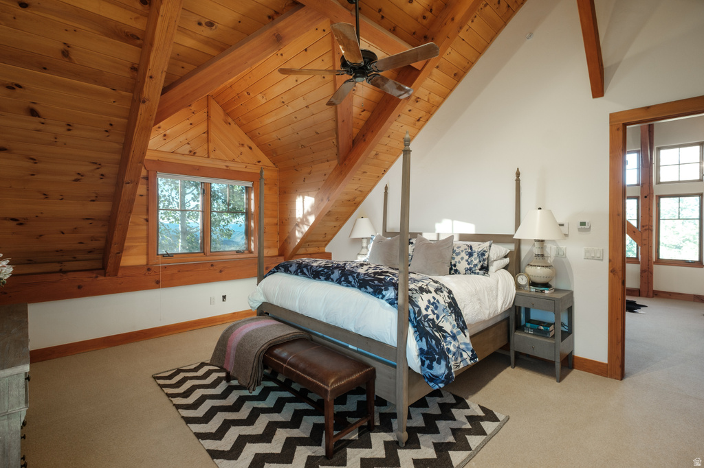 Vaulted wood-paneled ceilings with exposed beams, central ceiling fan, two-pane window, and carpeted flooring