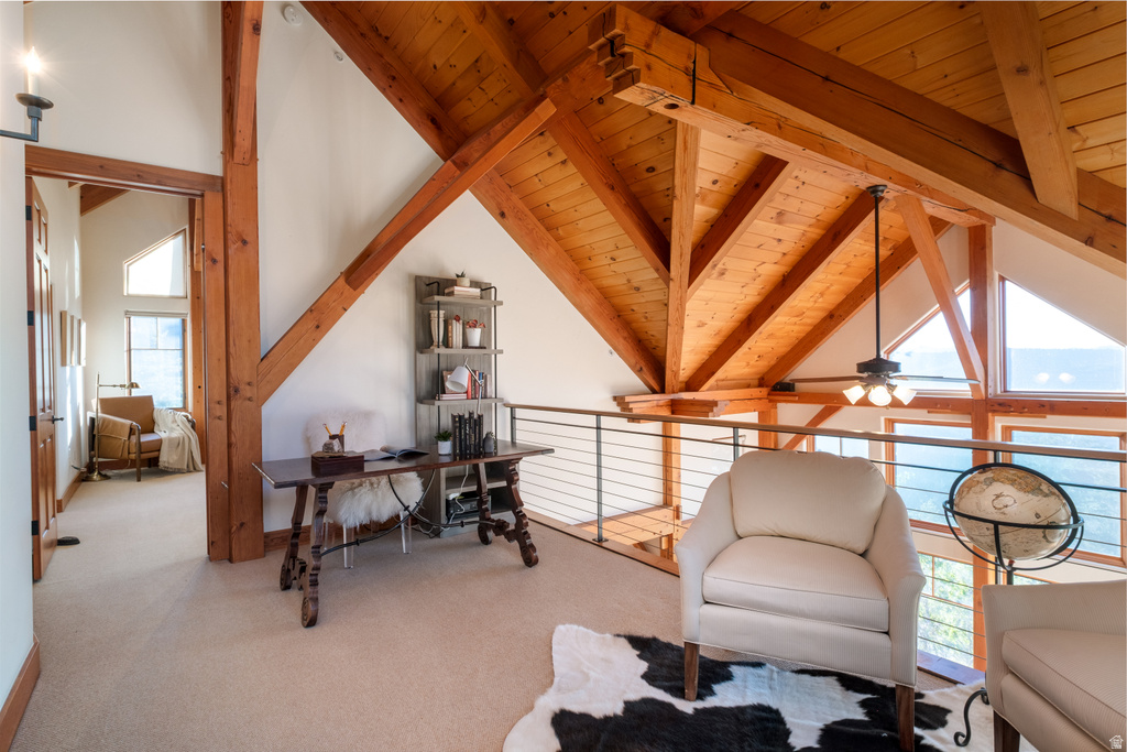 Loft space featuring exposed natural wood beams and ceiling, a cable railing system, triangular accent windows, and carpeted flooring