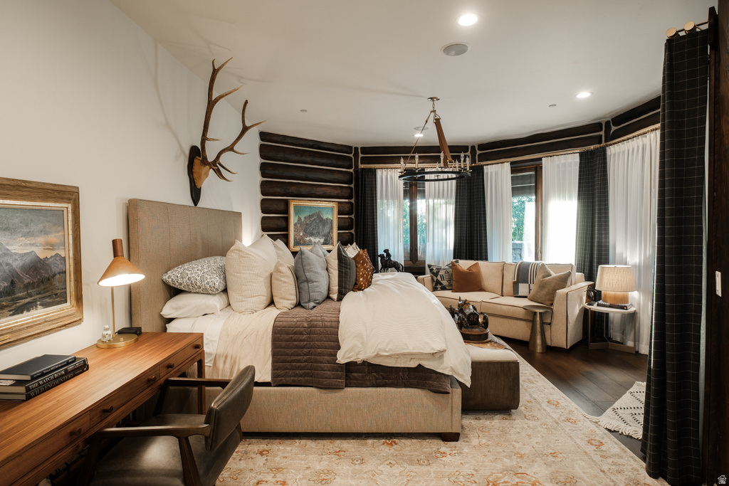 Spacious room featuring wood-finish flooring, a tray ceiling with recessed lighting, and a chandelier