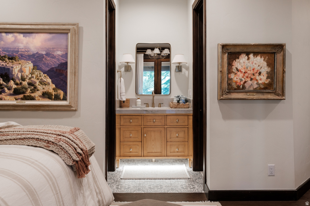 Natural wood vanity with integrated sink, stone countertop, and two wall sconces