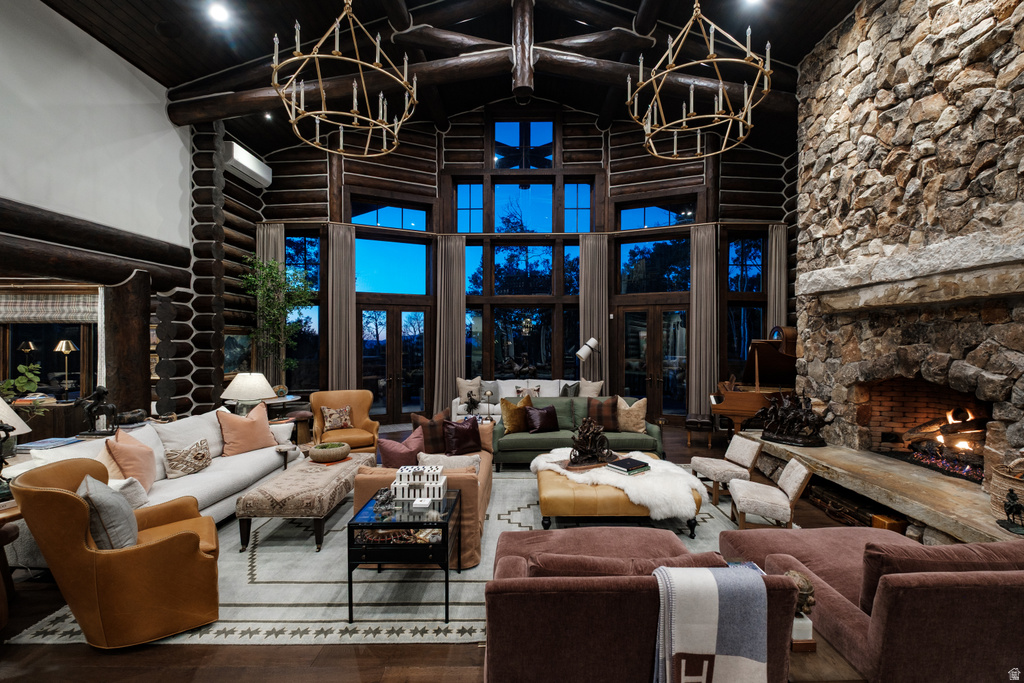 Grand living area featuring a floor-to-ceiling stone fireplace, exposed log beam construction, and expansive windows