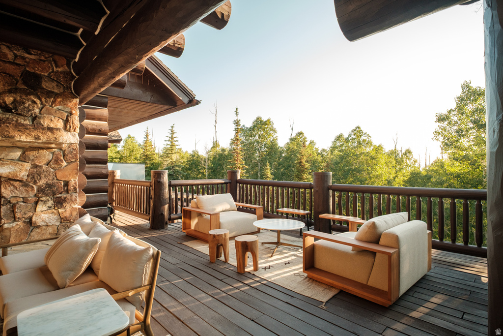 Expansive outdoor deck featuring dark wood-finish flooring and a robust log railing system