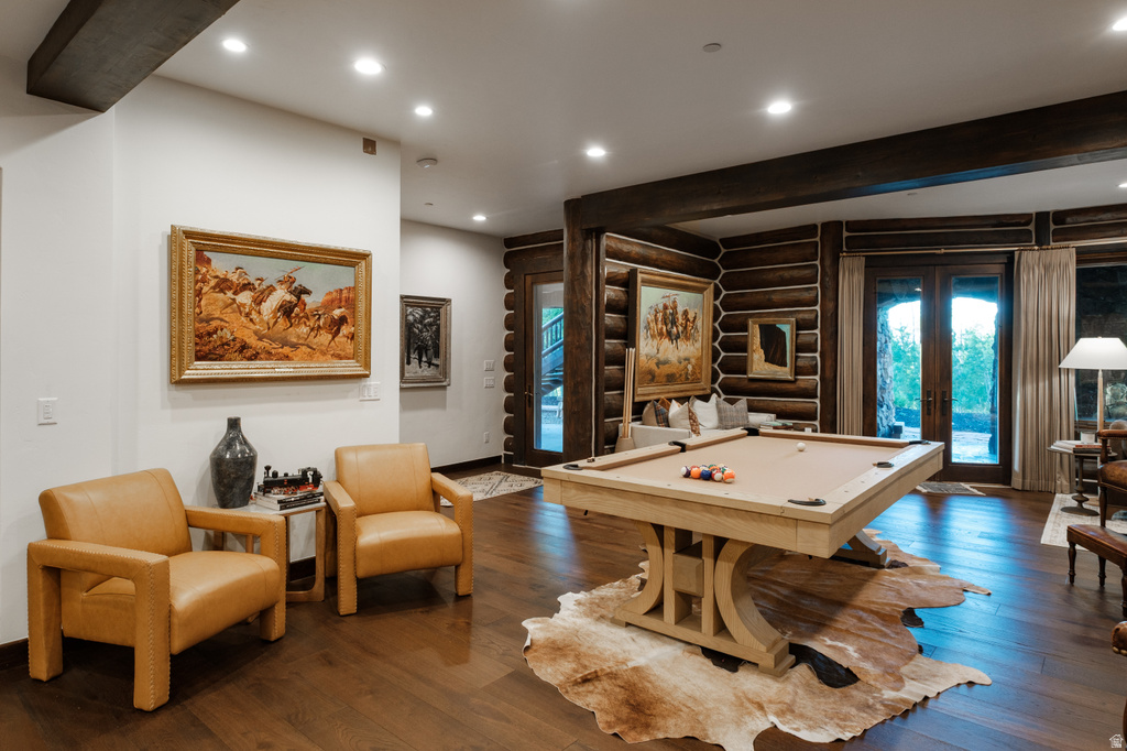 Spacious recreation area featuring wood-finish flooring, exposed wood beams, and recessed lighting