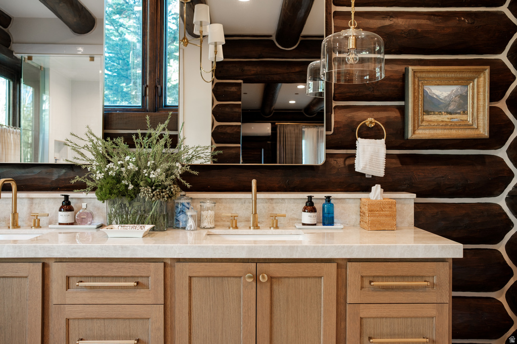 Dual undermount sinks with gold-toned fixtures complement the light-toned countertop
