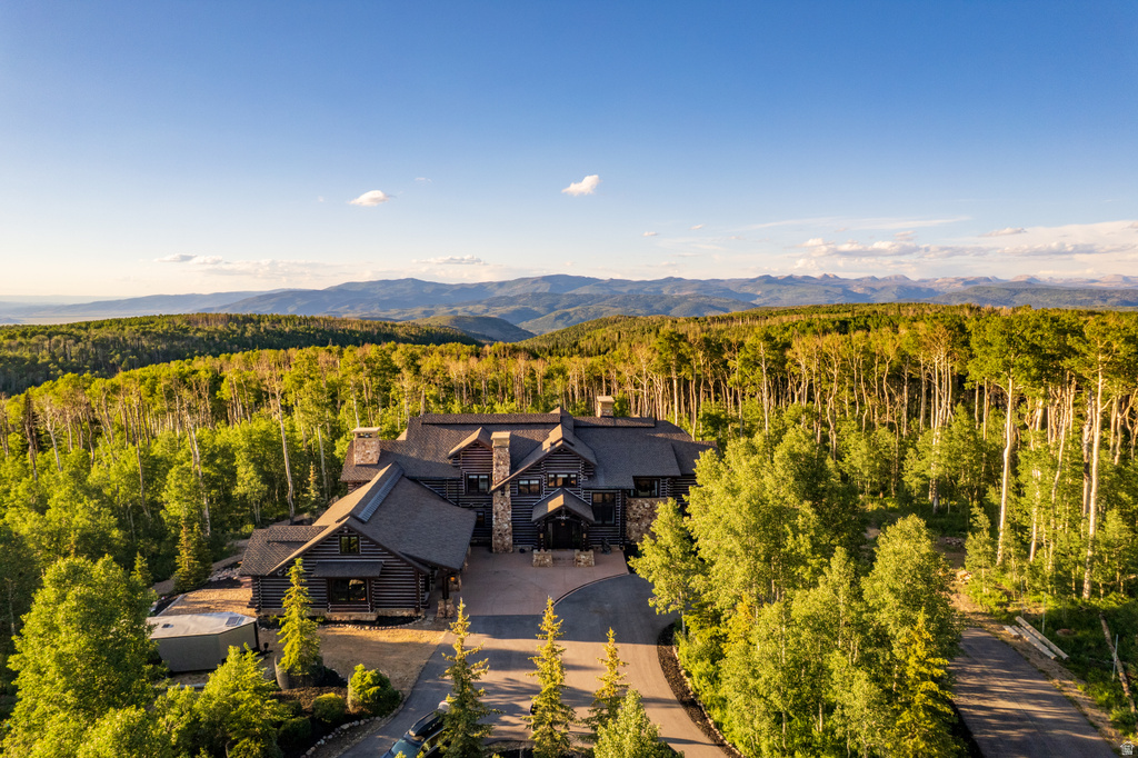 Expansive estate featuring a multi-level structure with stone and wood siding
