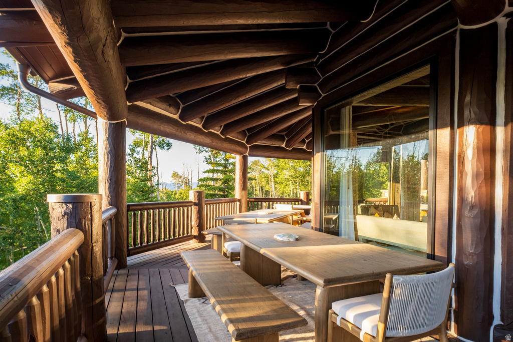 Expansive outdoor deck featuring substantial log construction and a wood-finish floor