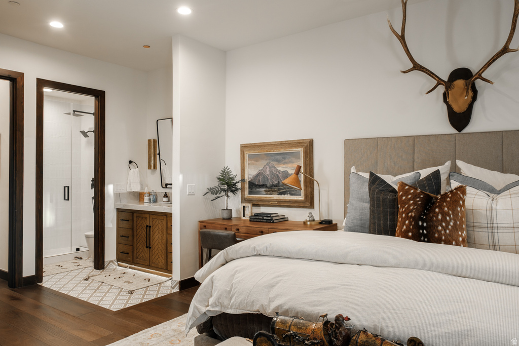 Bedroom featuring rich wood-finish flooring, a plush upholstered headboard, and recessed lighting