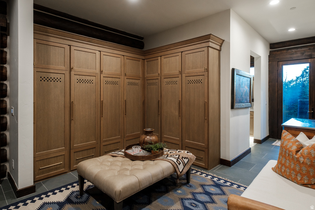 Built-in wood-finish cabinetry featuring ventilated panels and crown molding