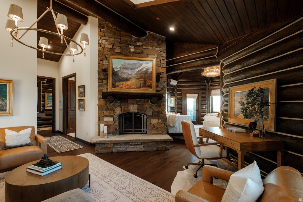 Stone-clad fireplace with hearth, dark wood-finish flooring, exposed log wall accents, vaulted wood plank ceiling, and a prominent chandelier